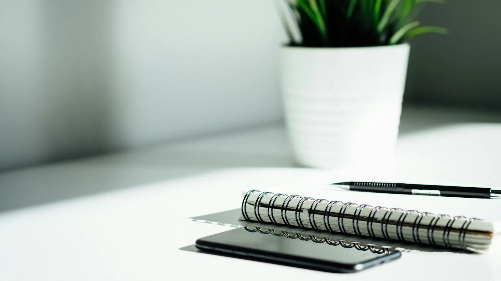 Notebook, pen and phone on a desk